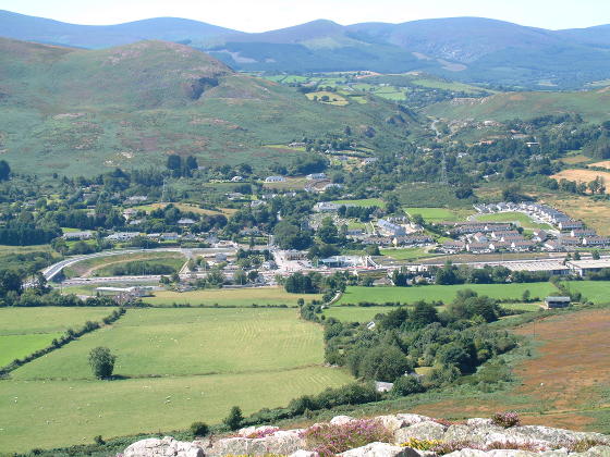 Looking from a hill towards a small village with mainly white buildings