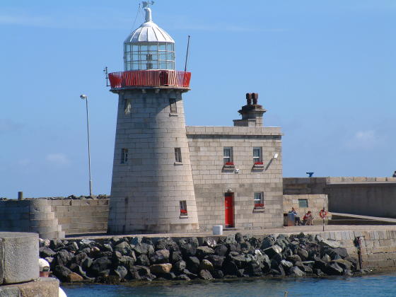 A grey lighthouse with house attached